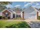 Charming one-story home featuring a well-manicured lawn, brick accents, and an attached two car garage at 10080 Highland Creek Cir, Indian Land, SC 29707