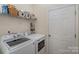 Functional laundry room features a side-by-side washer and dryer with overhead shelving at 10080 Highland Creek Cir, Indian Land, SC 29707