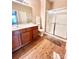 Well-lit bathroom featuring a double vanity, wood-look floor, and walk-in shower at 11264 Hyde Pointe Ct, Charlotte, NC 28262
