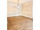 An empty dining room with wood floors, neutral walls, and a classic light fixture at 11264 Hyde Pointe Ct, Charlotte, NC 28262