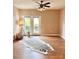 Bright living room with wood floors, ceiling fan, and double doors leading to a balcony at 11264 Hyde Pointe Ct, Charlotte, NC 28262