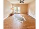 Bright living room features wood floors, a ceiling fan, and a door leading to the outside at 11264 Hyde Pointe Ct, Charlotte, NC 28262