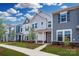 Charming townhome featuring various blue and gray color schemes, stone accents, and professionally landscaped yards at 10105 Mamillion Dr, Huntersville, NC 28078