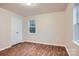 Bedroom with wood-look floors, large double door closet, and a bright window at 3004 Ridge Ave, Charlotte, NC 28208