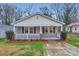 Charming single-story home featuring a cozy front porch with brick accents and a well-maintained lawn at 3004 Ridge Ave, Charlotte, NC 28208