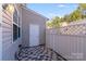 Fenced patio area with tiled floor, outdoor lighting, and white wooden fence at 563 Goldstaff Ln, Charlotte, NC 28273