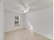 A clean bedroom with neutral flooring, a ceiling fan, and natural light from the window at 563 Goldstaff Ln, Charlotte, NC 28273