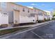 Charming townhomes boast neutral siding, white fences, and manicured landscaping at 563 Goldstaff Ln, Charlotte, NC 28273