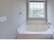 Bathroom with a soaking tub and a window that provides natural lighting at 8403 Spirea Ct, Charlotte, NC 28215