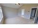 This bedroom includes neutral walls, a ceiling fan, and a door to an en suite bathroom at 8403 Spirea Ct, Charlotte, NC 28215