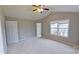 This bedroom has neutral walls, a ceiling fan, and a double window for natural light at 8403 Spirea Ct, Charlotte, NC 28215
