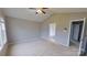 This bedroom includes neutral walls, a ceiling fan, and a door to an en suite bathroom at 8403 Spirea Ct, Charlotte, NC 28215