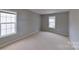 The bedroom features neutral walls and carpet, plus two double-hung windows for natural light at 8403 Spirea Ct, Charlotte, NC 28215