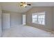This bedroom has neutral walls, a ceiling fan, and a double window for natural light at 8403 Spirea Ct, Charlotte, NC 28215