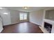 Spacious living room features a fireplace, window, and staircase access enhancing the home's appeal at 8403 Spirea Ct, Charlotte, NC 28215
