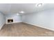 Bright basement featuring neutral walls, wood-look floors and a white brick fireplace at 919 N Weldon St, Gastonia, NC 28052