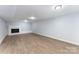 Bright basement featuring neutral walls, wood-look floors and a white brick fireplace at 919 N Weldon St, Gastonia, NC 28052