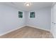 Bright bedroom featuring neutral walls, wood-look floors, and two windows letting in natural light at 919 N Weldon St, Gastonia, NC 28052