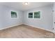Bright bedroom featuring wood-look floors, neutral walls, and natural light from two windows at 919 N Weldon St, Gastonia, NC 28052