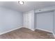 A bedroom featuring hard wood floors, light-blue painted walls and a closet at 919 N Weldon St, Gastonia, NC 28052