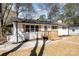 View of the white brick ranch showcasing the front porch and a concrete pathway and lawn at 919 N Weldon St, Gastonia, NC 28052