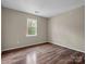 Simple bedroom with hardwood floors and a window at 10105 Reindeer Way Ln, Charlotte, NC 28216