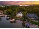 Stunning aerial view of a luxurious lakefront estate with multiple boat docks and lush green landscaping at 16921 Jetton Rd, Cornelius, NC 28031