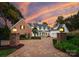 Elegant brick and white home with manicured landscaping, a circular driveway, and lantern-style lighting at 16921 Jetton Rd, Cornelius, NC 28031