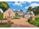 Impressive estate featuring a brick driveway, manicured landscaping, and a grand entrance with multiple garages at 16921 Jetton Rd, Cornelius, NC 28031