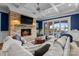 Comfortable living room features coffered ceilings, a brick fireplace, and lake views with access to the pool at 16921 Jetton Rd, Cornelius, NC 28031