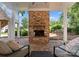 Inviting covered patio featuring a brick fireplace and comfortable seating, perfect for outdoor relaxation at 16921 Jetton Rd, Cornelius, NC 28031