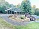 Gravel backyard featuring a metal carport, stone landscaping, and wooden stairs at 287 Ben Eller Ln, Taylorsville, NC 28681