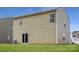 A shot of the property's exterior with a well-maintained lawn, siding, and a sliding glass door to access the backyard at 110 Dorian Pl, Troutman, NC 28166