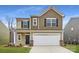 Charming two-story home featuring a two-car garage, black shutters, and manicured lawn at 110 Dorian Pl, Troutman, NC 28166