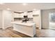 Modern kitchen with white cabinets, stainless steel appliances, and a large island with a sink at 110 Dorian Pl, Troutman, NC 28166