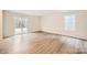 Bright living room featuring hardwood floors, white walls, and sliding door to the backyard at 110 Dorian Pl, Troutman, NC 28166