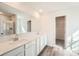 Bathroom featuring a double sink vanity with quartz countertop, modern fixtures, and access to a walk-in closet and shower at 112 Dorian Pl, Troutman, NC 28166