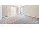 Carpeted bedroom with double doors, a window, and neutral walls, creating a serene and adaptable living space at 112 Dorian Pl, Troutman, NC 28166