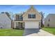 Charming two-story home with a modern design, complemented by a well-manicured lawn and attached garage at 112 Dorian Pl, Troutman, NC 28166