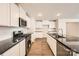 Modern kitchen with stainless steel appliances, granite countertops, white cabinets and wood-look flooring, offering a sleek and functional design at 112 Dorian Pl, Troutman, NC 28166