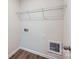 Empty laundry room with wood-look flooring, showcasing the utility connections and a blank canvas for customization at 112 Dorian Pl, Troutman, NC 28166