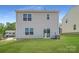 View of the home's backyard featuring a sliding glass door and newly installed lawn at 123 Dorian Pl, Troutman, NC 28166