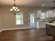 Open dining room with modern chandelier open to the kitchen and backyard at 1117 Shadowmoss Ct, Salisbury, NC 28147