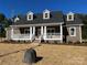 Brick home featuring a covered front porch with white columns, dormer windows, and manicured landscaping at 1117 Shadowmoss Ct, Salisbury, NC 28147