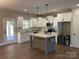 Bright kitchen featuring an island, white cabinets, and stainless steel appliances at 1117 Shadowmoss Ct, Salisbury, NC 28147