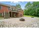 A spacious backyard with a stone fire pit and a brick patio beneath a wooden deck at 1567 Fayrene Rd, Rock Hill, SC 29732