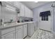 Bright laundry room with washer, dryer, sink, storage cabinets, and access to the outdoors at 1567 Fayrene Rd, Rock Hill, SC 29732