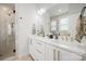 Double vanity bathroom with white cabinets, gold fixtures, and a large mirror at 1925 Dunavant St, Charlotte, NC 28203