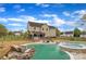 A backyard featuring a spacious pool with a rock waterfall feature and a hot tub, with a covered patio and fenced yard at 500 Pearl Place Ln, York, SC 29745