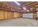 Unfinished spacious garage with wood walls, concrete floors, and a white garage door at 500 Pearl Place Ln, York, SC 29745